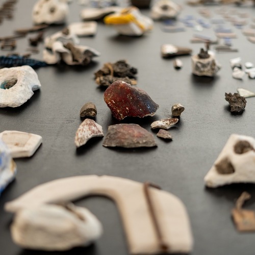Kamienie oraz różne ceramiczne elementy na czarnym stole.