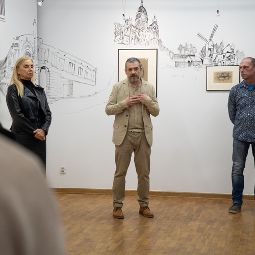 Przed publicznością stoją od lewej: dyrektor Galerii, kurator wystawy oraz autor rysunków.